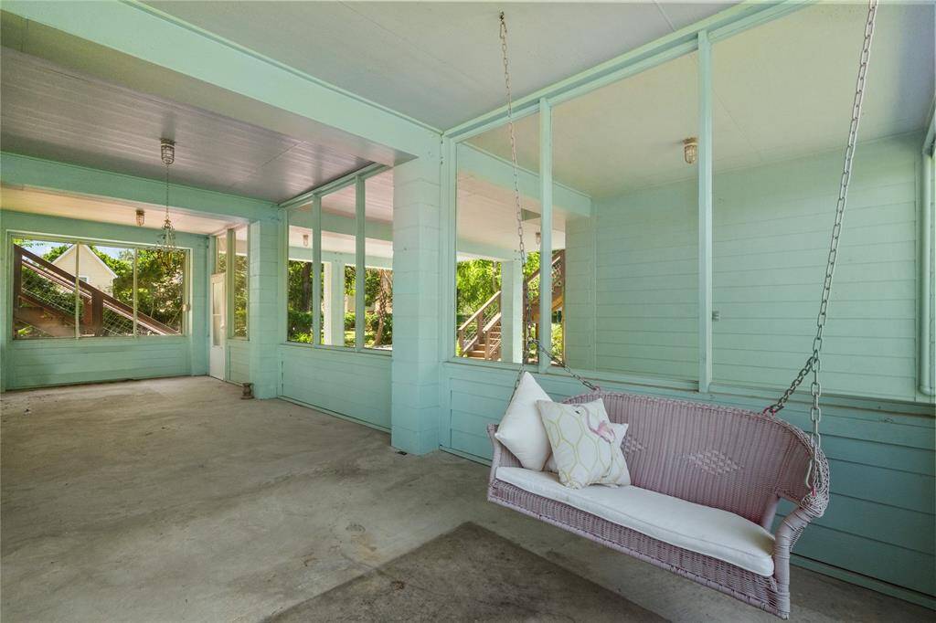 Inside of screened porch with a nice swinging bench.