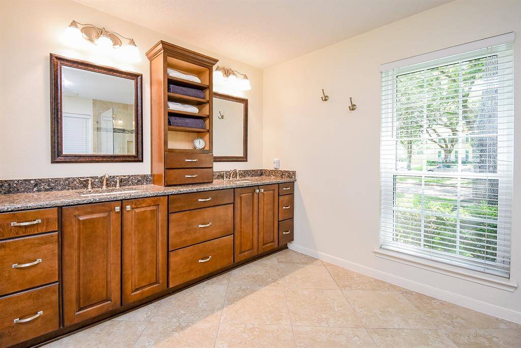 Primary Bath features copious storage space & towel shelving.