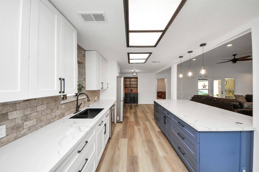 Enjoy ample storage with soft-close drawers and cabinets, a large one-bowl kitchen sink, and a beautiful travertine backsplash that perfectly complements the quartz countertops.