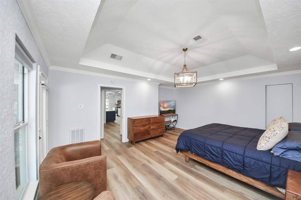 A sophisticated chandelier enhances the space within the recessed ceiling, adding a touch of timeless beauty.