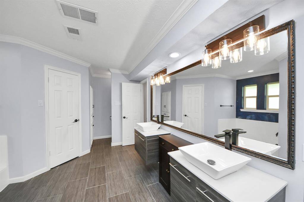 This bathroom is complemented by two sizable walk-in closets, offering ample storage and organization space.