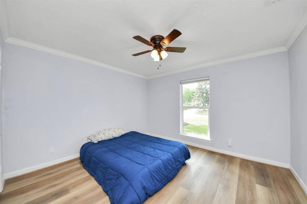 The second bedroom features elegant crown molding, a strategically placed window for natural light, and an ample closet for storage.