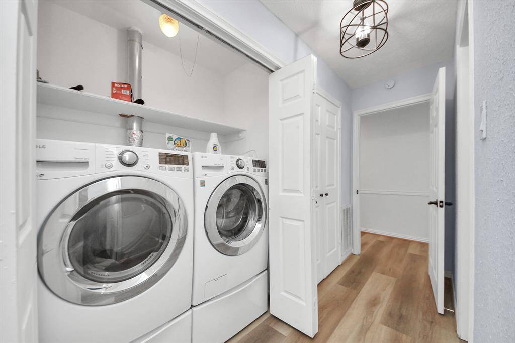 A dedicated laundry closet houses a full-size front-load washer and dryer, with a convenient overhead shelf for storing essentials and keeping everything within easy reach.