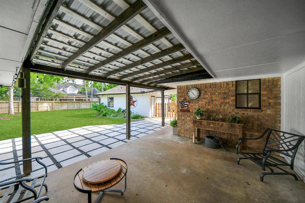 The covered back patio, topped with a durable metal roof, offers plenty of space for outdoor furniture—perfect for barbecues, entertaining, or simply enjoying quiet evenings outdoors.