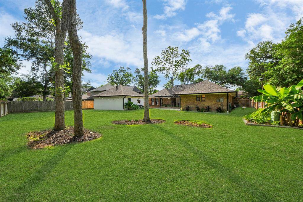 Mature trees, beautiful landscaping, and thoughtfully installed French drains create a low-maintenance backyard oasis—truly nothing left to do but sit back and enjoy.