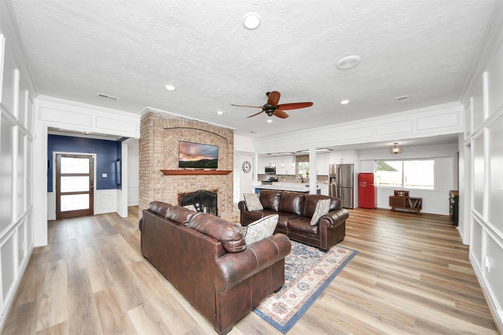 From this angle, you can see how the front entry opens into the heart of the home—leading to the inviting den where the backside of the brick wall reveals a warm, wood-burning fireplace.
