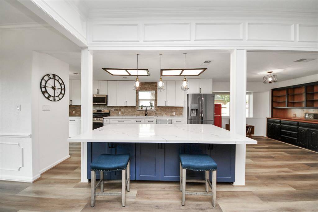 The spacious kitchen island features stunning quartz countertops, offering the perfect spot for buffets and food service in addition to room for casual seating with counter stools—ideal for gatherings and everyday living.