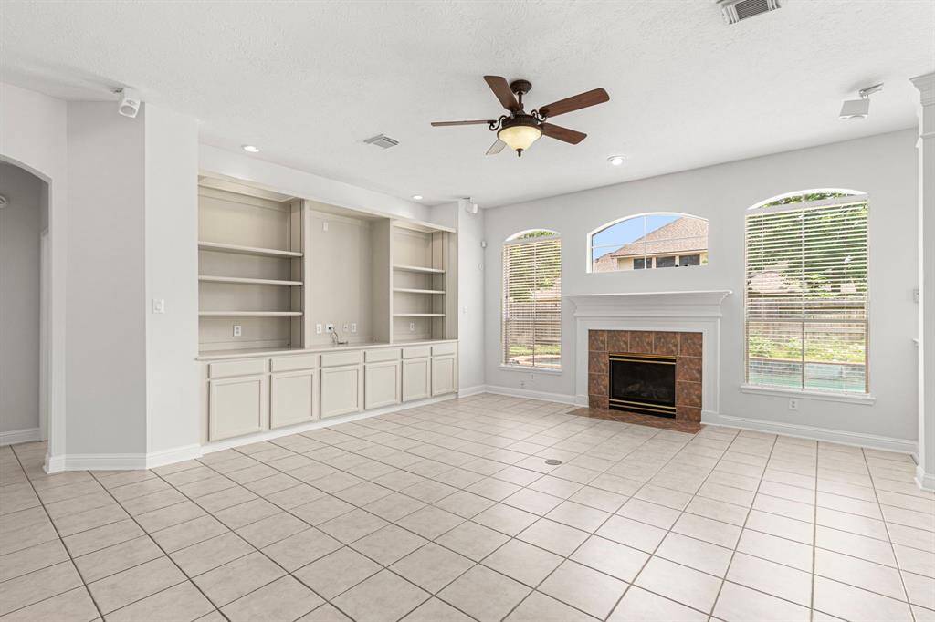 The family room has arched windows, a fireplace, and a wall of built-ins to display your collectibles and books.
