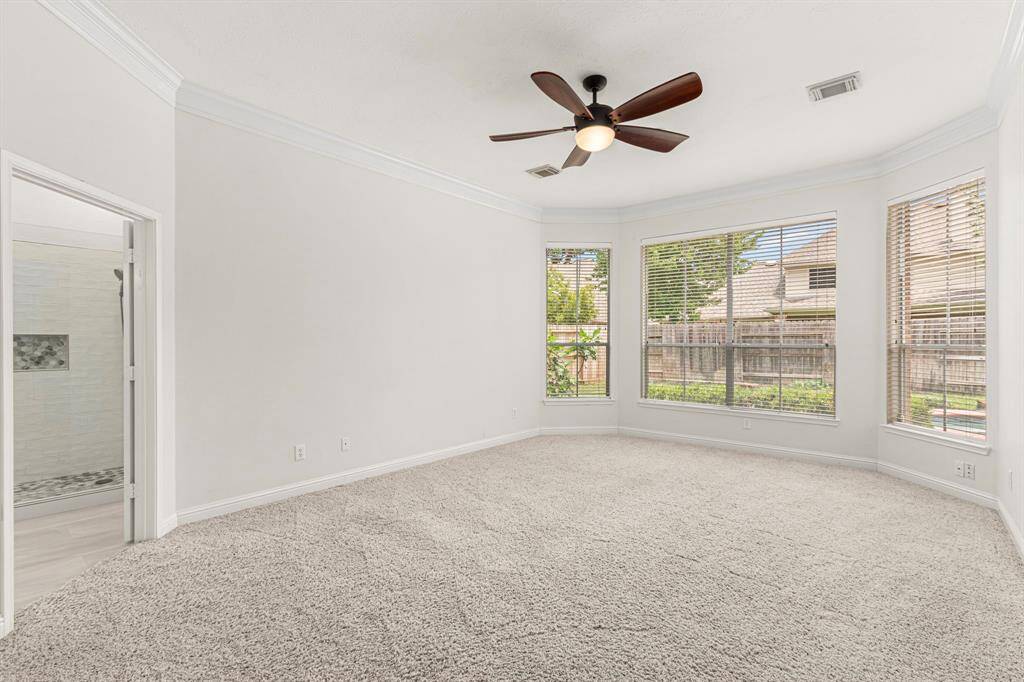 Primary bedroom has a bay window and double crown molding