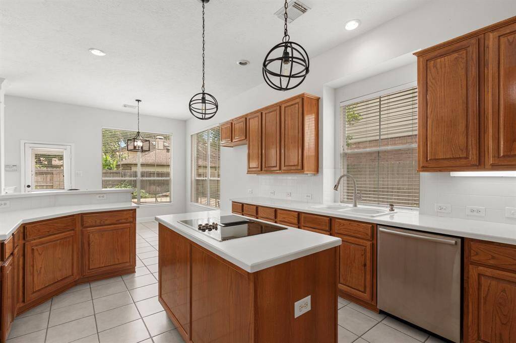 The kitchen has updated pendant lighting and stainless steel appliances.