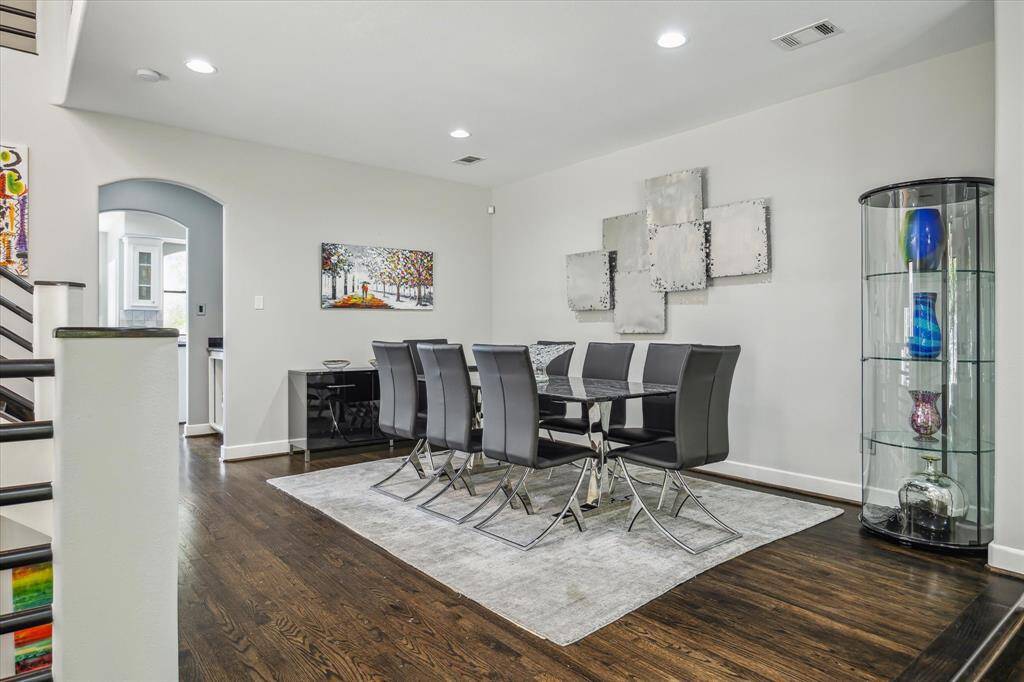 Dining area with high ceilings and rich dark wood floors.