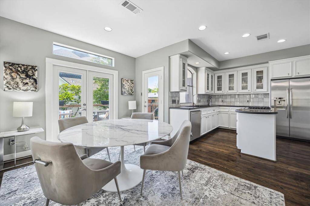 View of the breakfast area adjacent to the kitchen and French doors lead to a tree top balcony which overlooks the pool.
