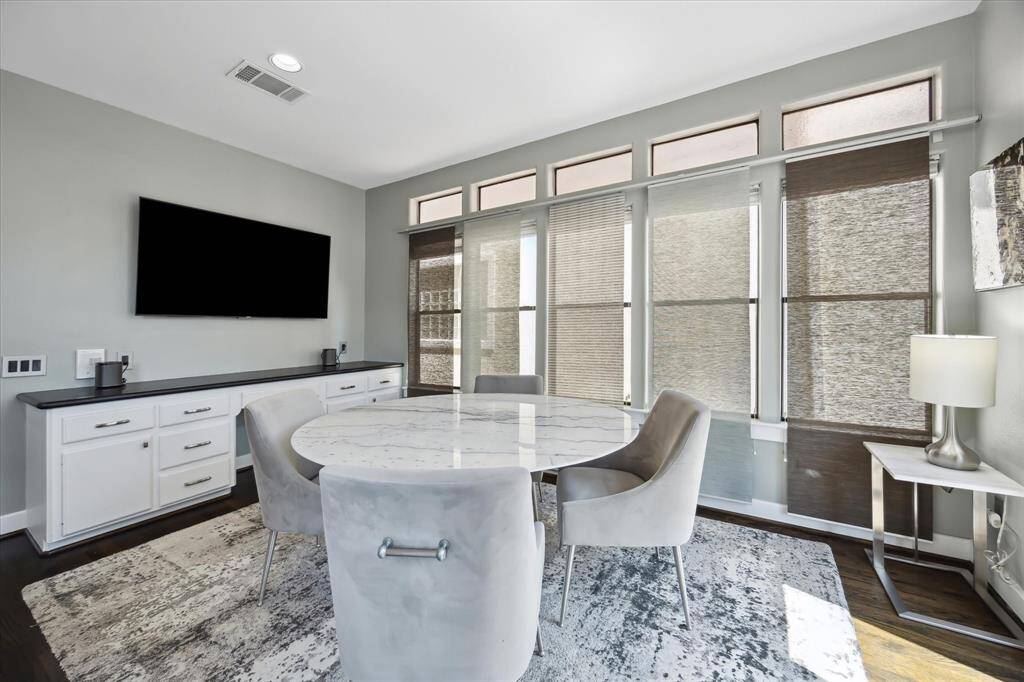 Breakfast area with built-in desk and storage and custom window coverings on a track system.