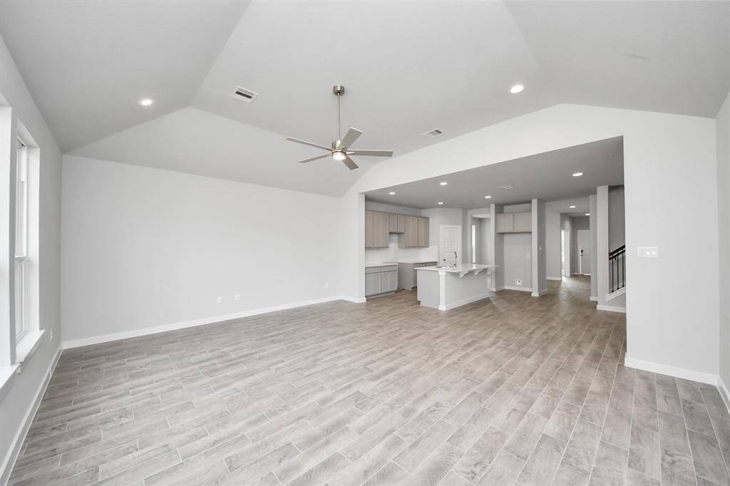 Gather the family and guests together in your lovely living room! Featuring soaring highceilings, recessed lighting, ceiling fan, custom paint, gorgeous floors, and large windows thatprovide plenty of natural lighting throughout the day.