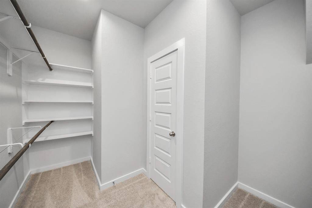 Walk-in closet that epitomizes luxury and practicality. This generously sizedspace features built-in shelving, offering abundant room for impeccableorganization. High ceilings and recessed lighting create a bright andwelcoming ambiance.