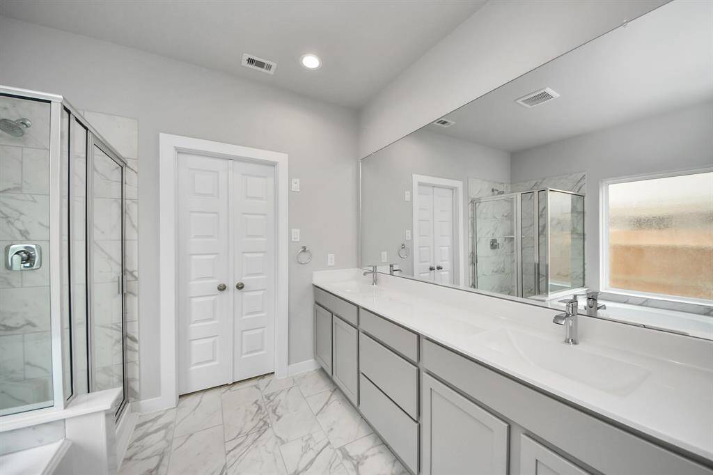 Elevate your dailyroutine at the elegant vanity, now equipped with double sinks, lightcountertops, modern hardware, and beautiful vanity lights.