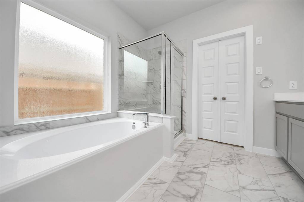 Indulge in the serenity of your primary bathroom, a true retreat designed for relaxation.