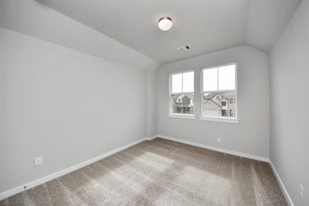 Secondary bedroom features plush carpeting, large windows that let in plenty of naturallight, bright paint, and spacious closets.
