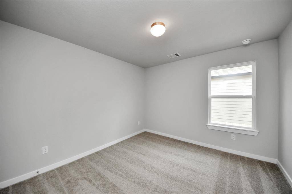 Secondary bedroom features plush carpeting, large windows that let in plenty of naturallight, bright paint, and spacious closets.