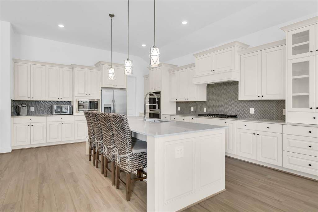 Enjoy breakfast with the family at the large island featuring brushed nickel pendulum lighting.