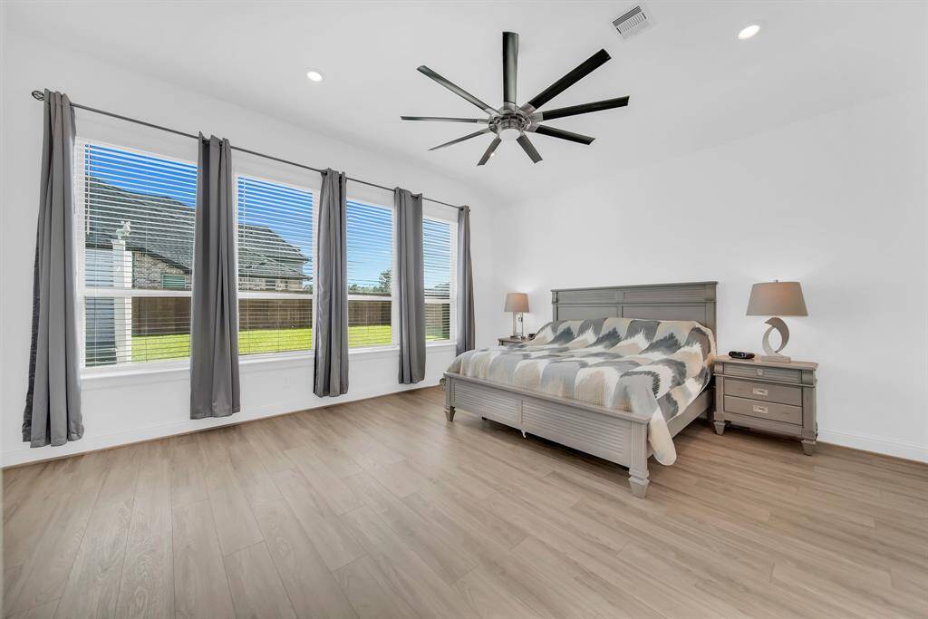 Primary bedroom with a wall of floor to ceiling windows.
