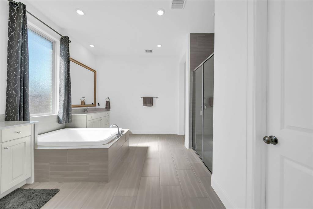 The primary bath includes double sinks, a large shower and soaking tub.