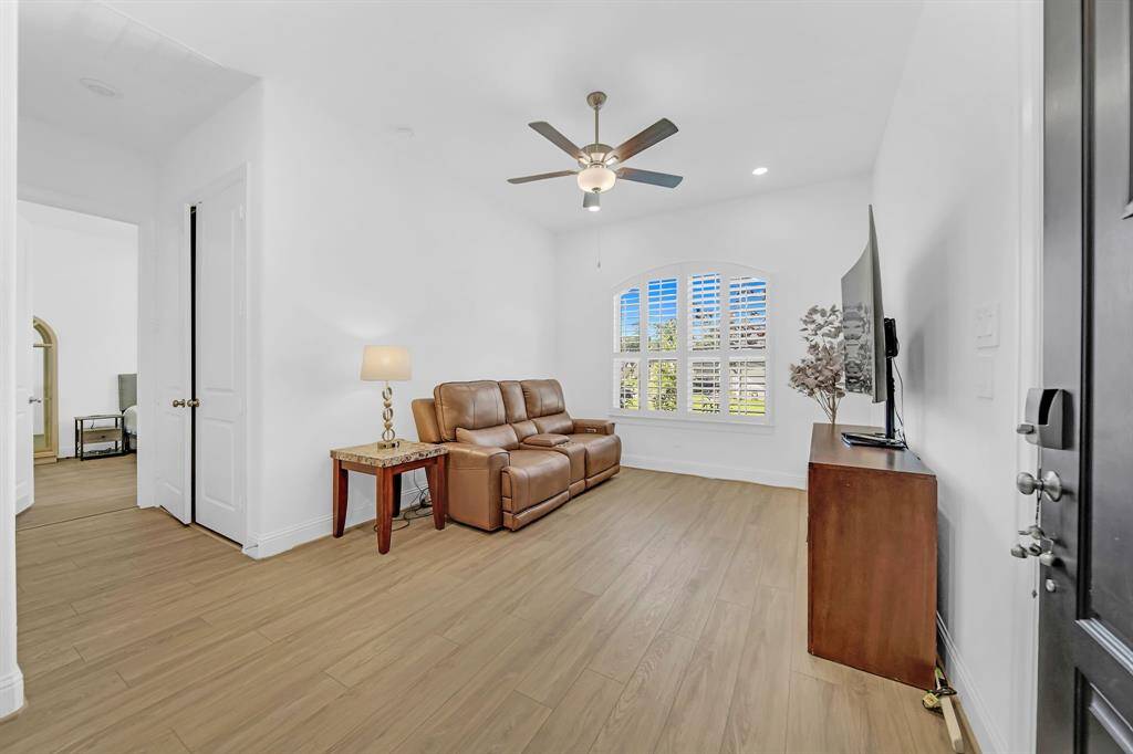 The Next-Gen living are located at the front of the home has a view of the beautifully landscaped front yard and has custom plantation shutters matching the other front facing windows.