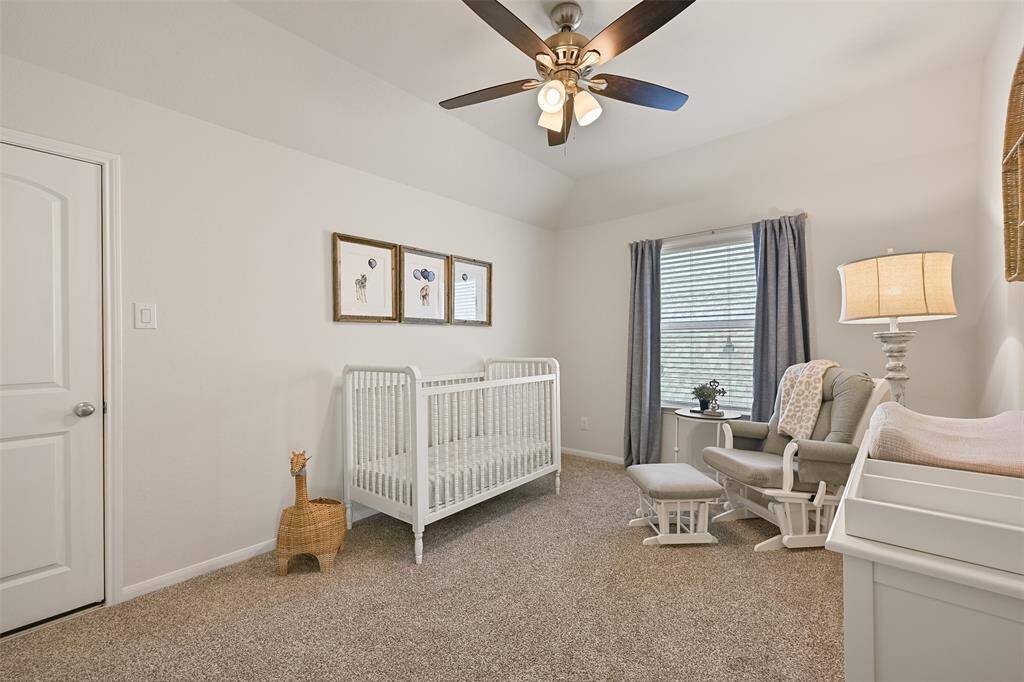 This bedroom is secluded off of one side of the gameroom and it offers a gambrel ceiling with a lighted ceiling fan, neutral paint, plush carpet, a side-facing window, two double door closets, walk-in attic access, and a private en suite bathroom.