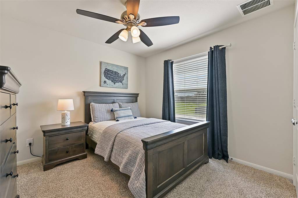 The remaining two bedrooms are located on the opposite side of the gameroom. This room features a lighted ceiling fan, a side-facing window shaded by 2-inch blinds, plush carpet, and a double-door closet.