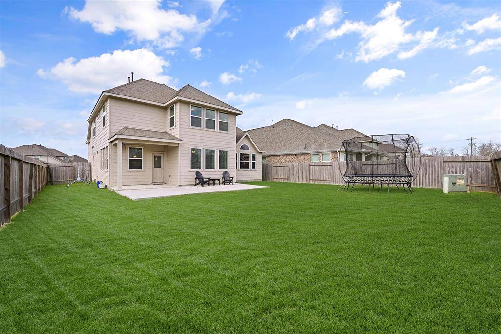 Step outdoors from the breakfast room onto this extended concrete patio that overlooks the lush carpet of St Augustine grass in this private backyard with a wood privacy fence and no neighbors to the rear or to the left side.