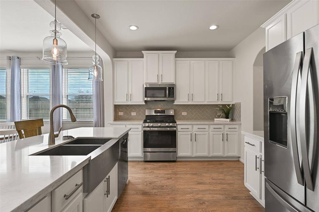 The chef of the house is certain to appreciate the roomy step-in pantry, the stainless appliances that include a gas cooktop with center griddle and a vent hood microwave, and the dual basin apron front sink with a built-in cup washer that could be converted back to a water filtration system.