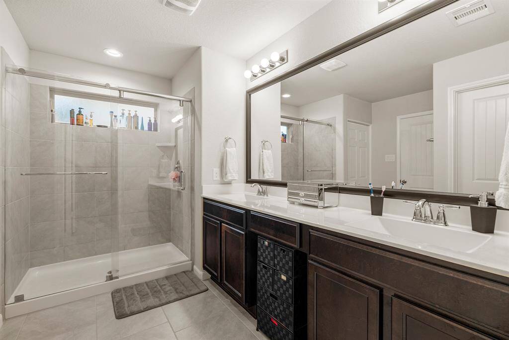 Experience luxury in the primary suite's ensuite bathroom, featuring double sinks and a light-filled shower.