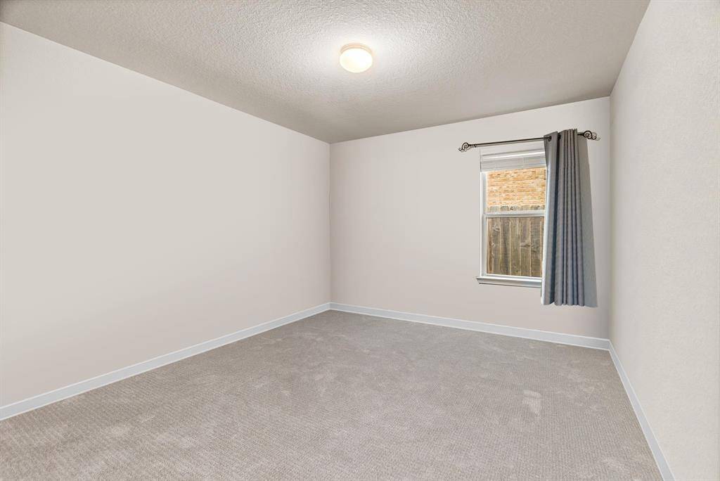 This inviting secondary bedroom offers a cozy and versatile space perfect for guests, children, or a home office. Featuring plush carpet, neutral tones, and a large window that brings in natural light, the room feels bright and welcoming. A standard closet provides convenient storage, and the quiet location within the home makes it a restful retreat for any occupant.