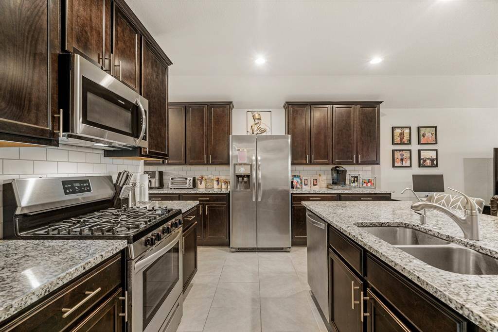 Experience culinary bliss in this kitchen, featuring a gas stove and expansive countertops.