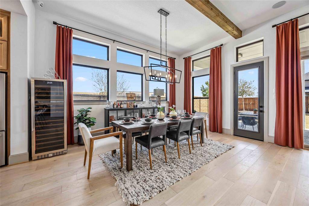 Surrounded by oversized windows and warm natural light, the dining room offers a stylish and spacious setting perfect for everyday meals or hosting guests.