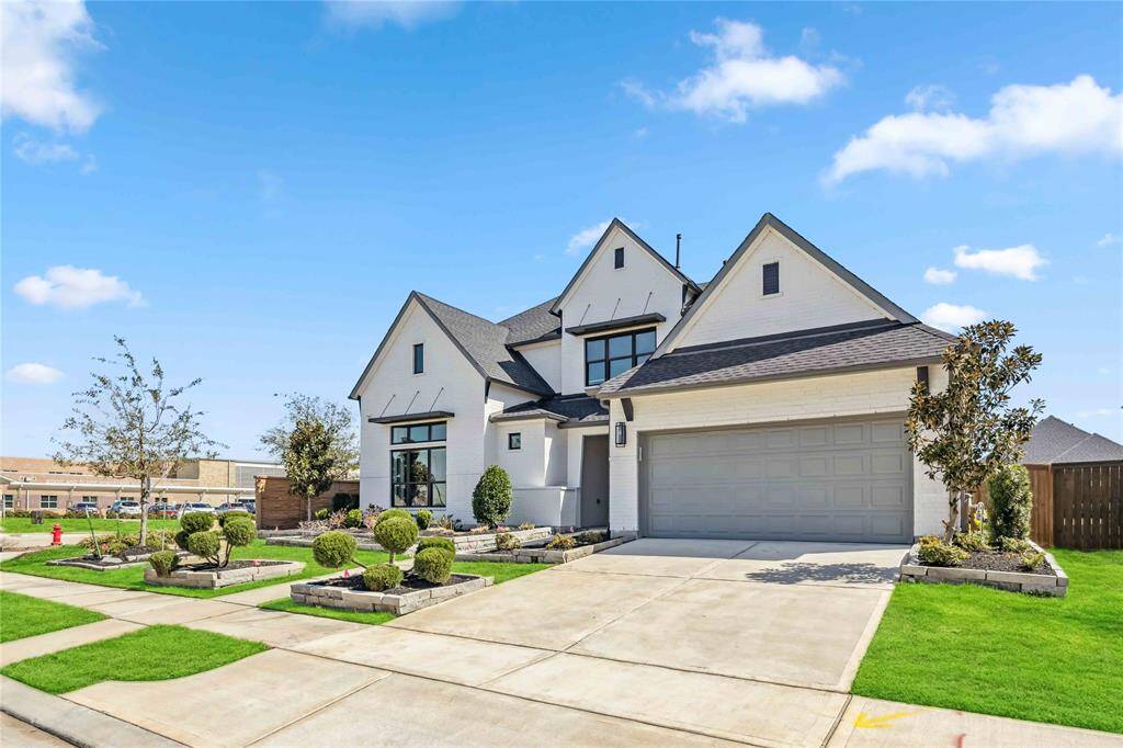 Impressive curb appeal with a two-car garage, manicured landscaping, and a modern exterior design—conveniently located just across from Robertson Elementary.
