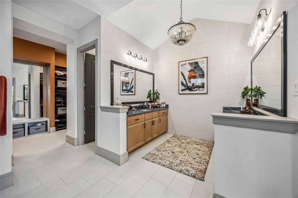 A wide layout offers ample counter space, dual mirrors, and easy access to the walk-in closet, combining convenience with elegant design.