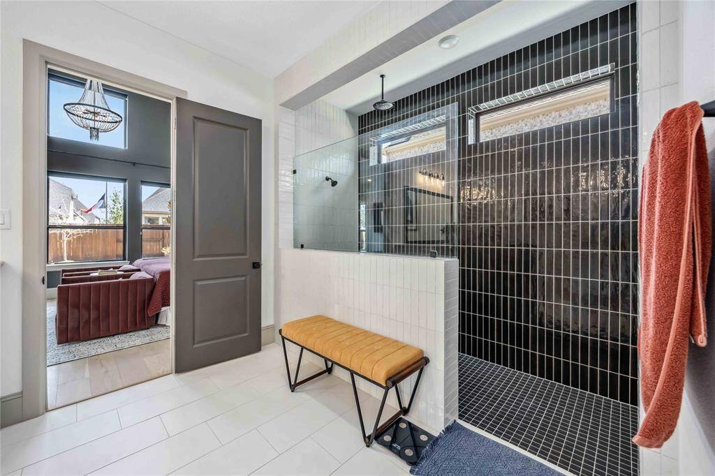 Enjoy a spa-like experience in the oversized walk-in shower, complete with striking floor-to-ceiling black tile and dual shower heads.
