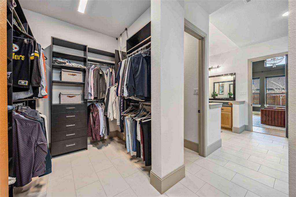 The walk-in closet offers built-in shelving, hanging space, and drawers—providing organized, spacious storage with direct access to the bathroom.