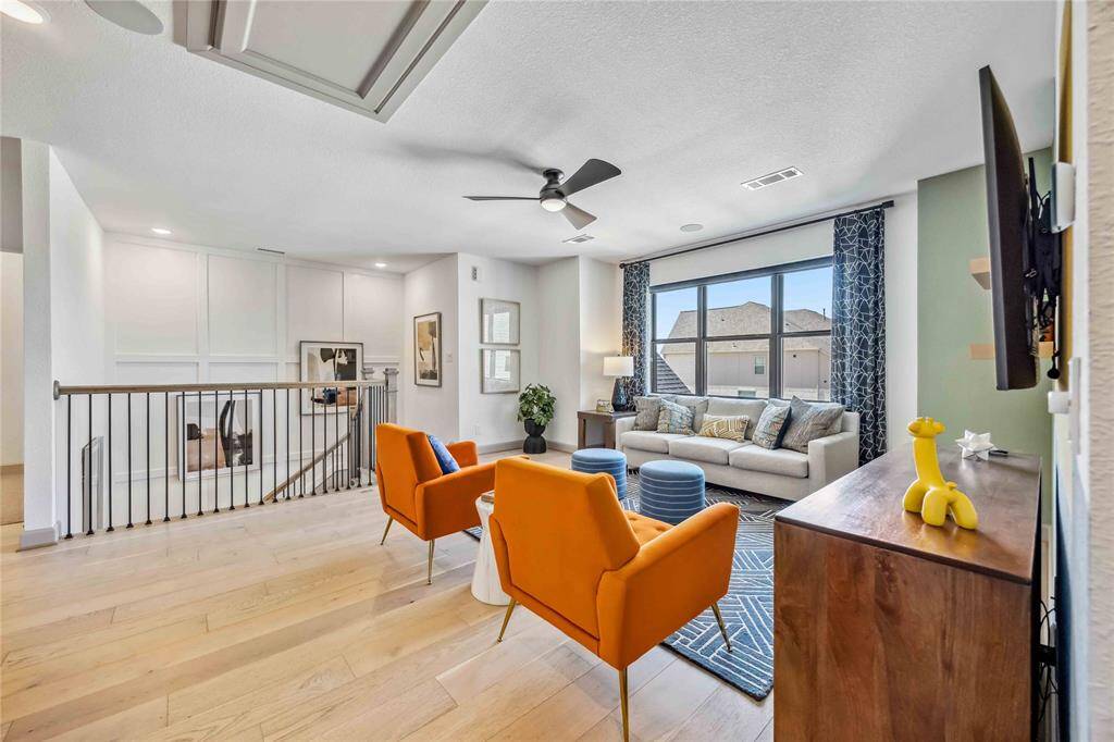 The upstairs retreat features a spacious lounge area with oversized window and stylish finishes—ideal for family hangouts or entertaining.