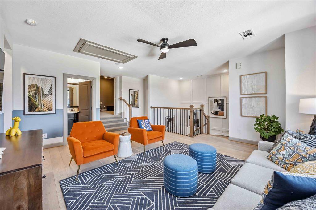 This vibrant upstairs loft offers a flexible layout for a game room, play area, or additional living space, filled with natural light and colorful, modern design.