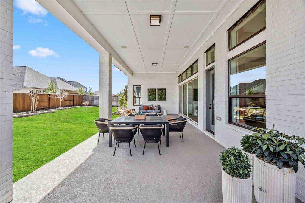 This extended patio provides plenty of room for dining and relaxing, with a view of the well-manicured backyard and privacy fence.