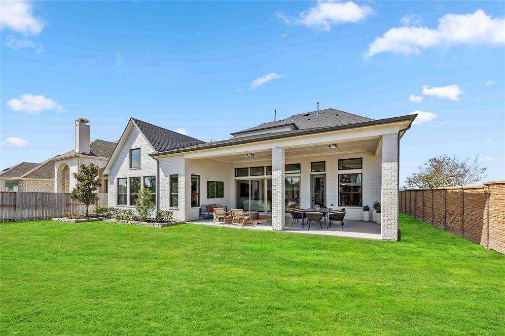 Enjoy outdoor living year-round on the expansive covered patio overlooking the lush backyard—perfect for entertaining or relaxing in comfort.
