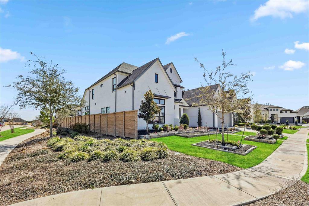 Beautiful corner-lot location offers added privacy and curb appeal, with manicured landscaping and direct sidewalk access to scenic community paths.