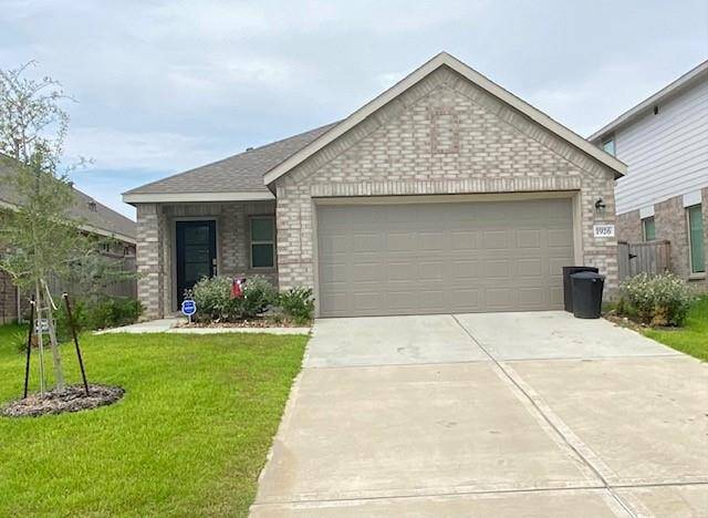 This is a single-story, brick-front home featuring a two-car garage, a well-maintained lawn, and a modest front entryway.