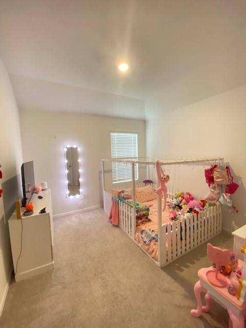 This is a cozy, well-lit children's room with a playful and inviting decor, featuring a large window for natural light, and is currently furnished with a crib and children's furniture.