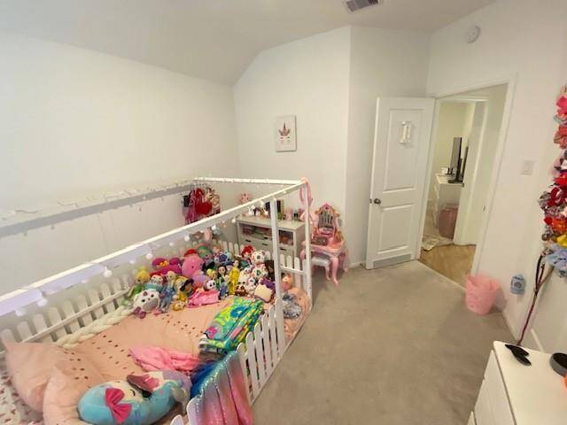 This is a cozy, well-maintained children's bedroom featuring a white crib filled with plush toys and a playful decor. The room includes a door leading to an adjoining area, suggesting an en suite or a connected room, enhancing the functionality of the space.