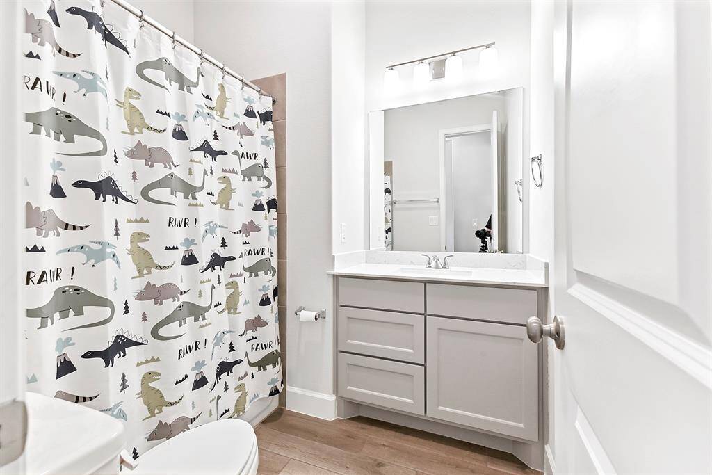 The full guest bathroom, shared between two of the bedrooms, features a tub/shower combo and a full vanity with sink.