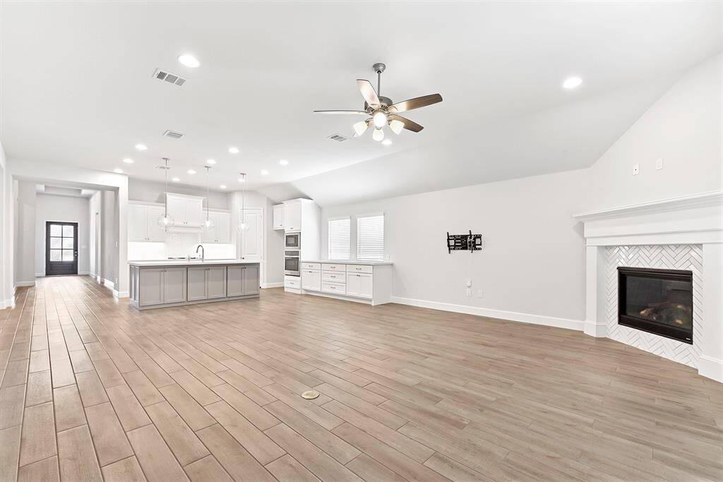 The home features a spacious open-concept design, perfect for both formal dining and living areas. A cozy gas fireplace adds warmth and charm, while the wood-look tile flooring throughout is both stylish and easy to maintain. Don’t miss the in-floor electrical outlet—ideal for placing a lamp or charging devices next to your favorite chair or sofa.