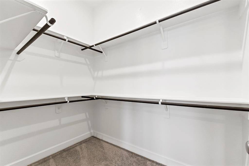The two walk-in closets offer ample hanging rods and built-in shelving for excellent storage and organization.